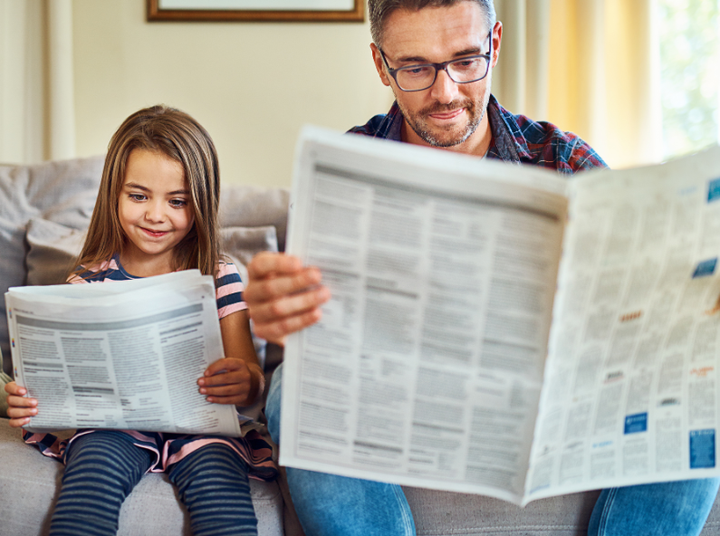 Dad and daughter reading a newspaper